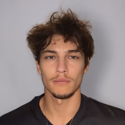 Portrait d'un jeune homme aux cheveux bruns ébouriffés, à la barbe légère, portant une chemise noire sur fond gris.